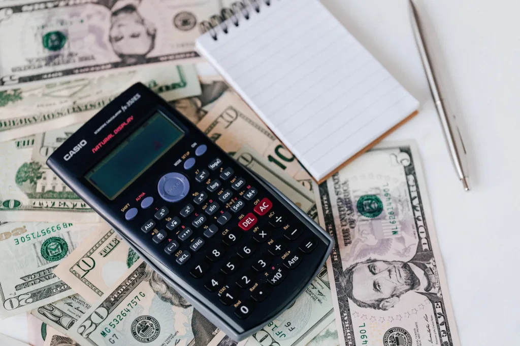 Calculator with money and notebook to count price of car